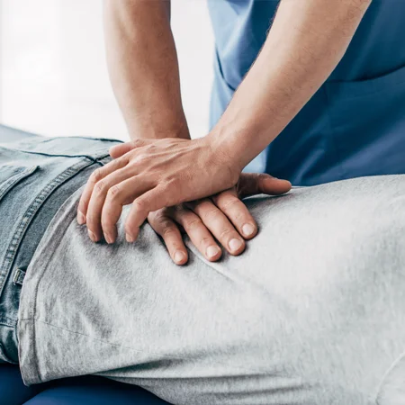 A chiropractor adjusting a patient's lower back